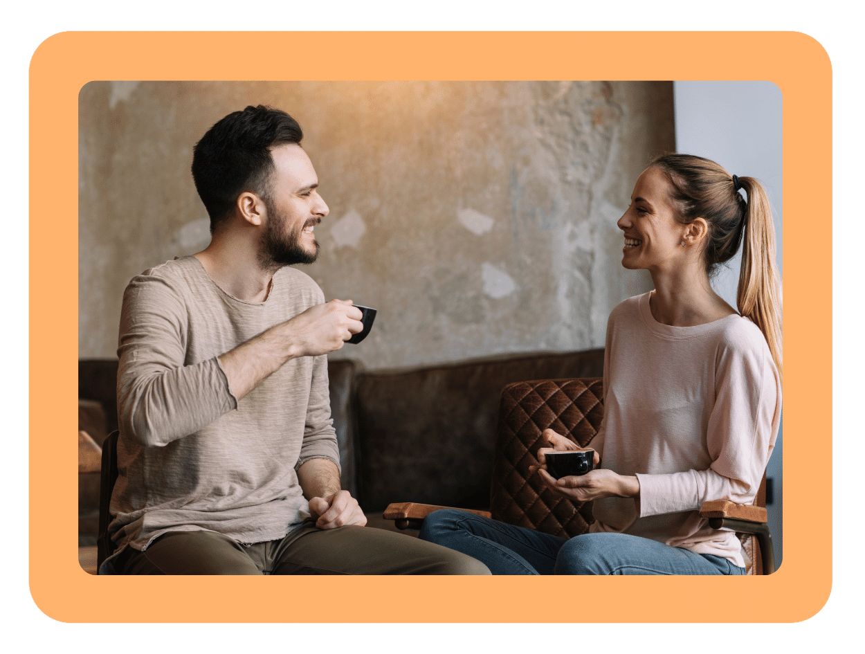 Zwei Menschen sitzen sich gegenüber und trinken Kaffee